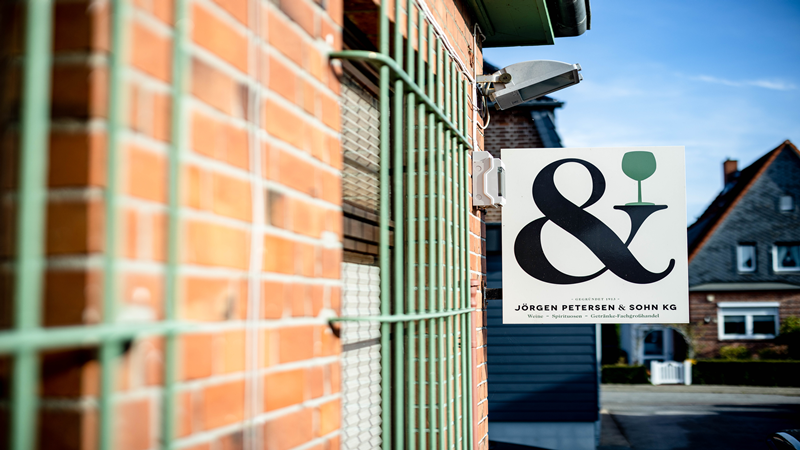 Ausschnitt eines Mauerwerks linksseitig zu sehen, daran hängt ein Schild